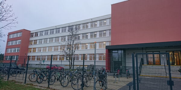 Blick auf das vierstöckige Schulgebäude und den Fahrradstellplatz