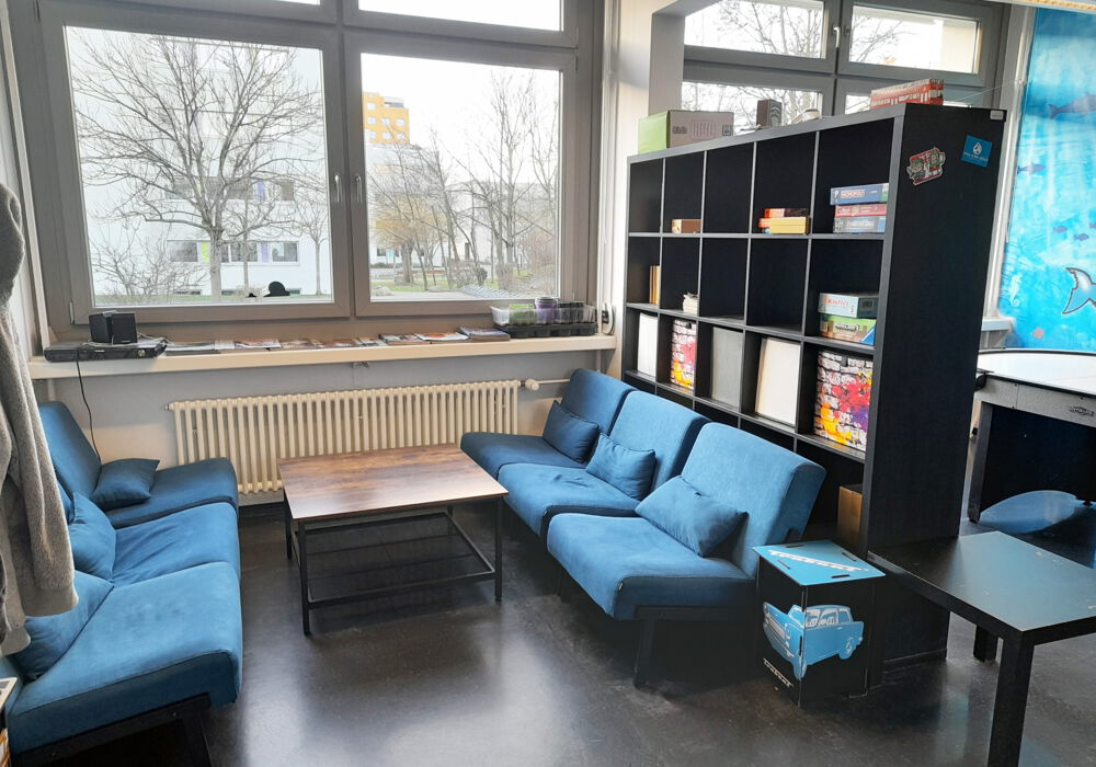 Schulclub Lene-Voigt-Schule zwei gemütliche blaue Sofas und ein kleiner Tisch im Aufenthaltsraum des Schulclubs